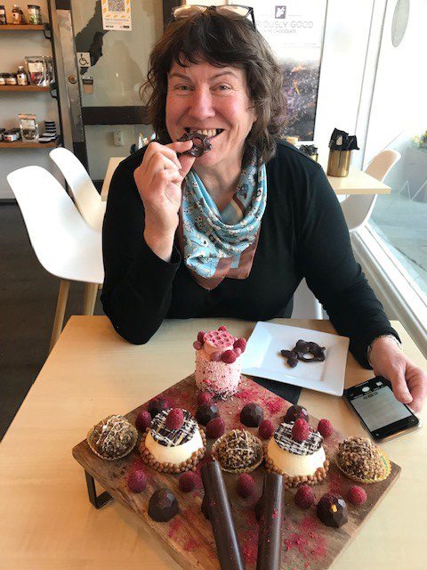 Woman sitting at table with display of fancy chocolates in front of her