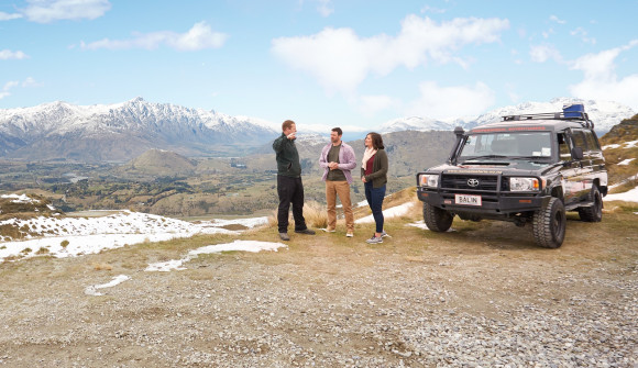 A couple talk with a guide while on an adventure tour near Queenstown
