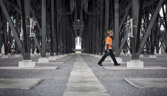 A worker strides along between the equipment at Ngatamariki power station