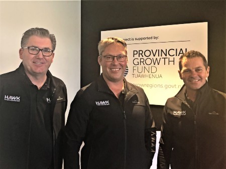 Three men in black smiling in front of a sign that says Provincial Growth Fund.
