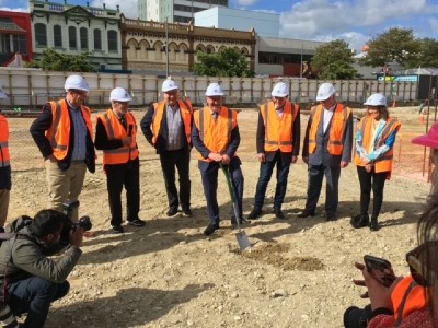 A group in orange high-vis vests and white hard hats.