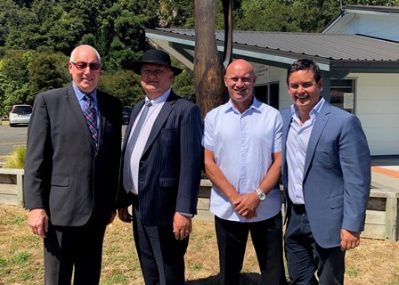 Four men standing together outdoors.