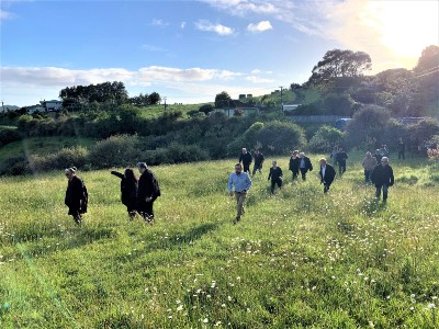 Kaumatua and local people walking across the meadow to the Te Haumanu o Te Kapua site for the blessing