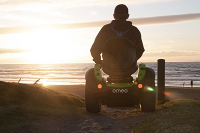 Man using an Omeo Technology wheelchair on a beach.