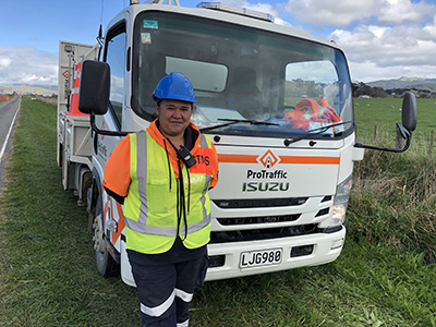 Tania Coleman standing in front of a truck on the side of the road.