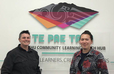 Rachel Hoskin and Shayna Te Riaki in front of the Te Pae Tata logo.