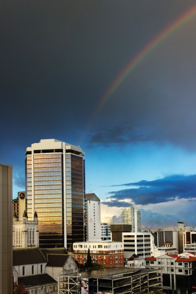 City buildings with a rainbow in the background.