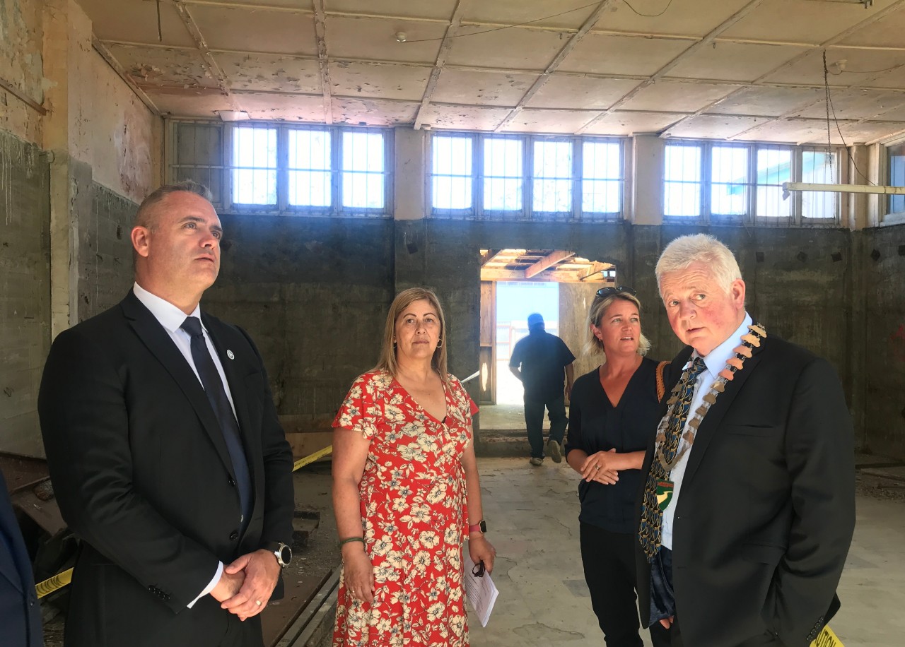 A group of people taking a tour of an abandoned building in Wairoa.