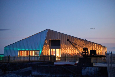 Photo of the new building on Wakatu Quay. It is shown in low light, probably at dawn.