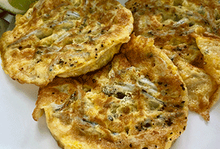 A close-up image of a plate of whitebait fritters.