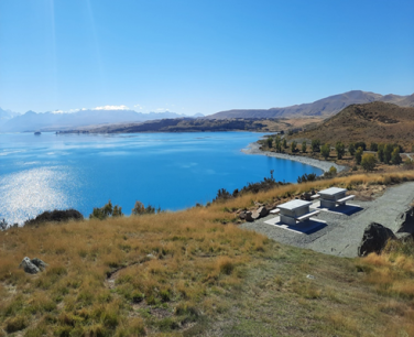 High angle shot over a vibrant blue body of water with mountains surrounding it