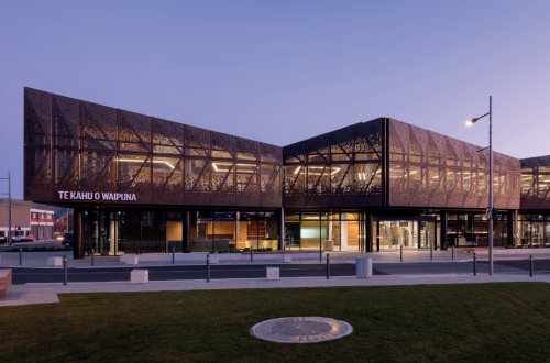 A modern two storey building with glass windows all around with 'Te Kahu o Waipuna' signage on the left of the building